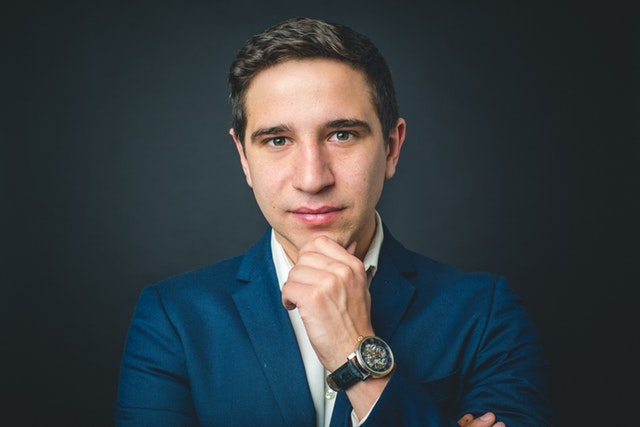 man in suit cupping chin